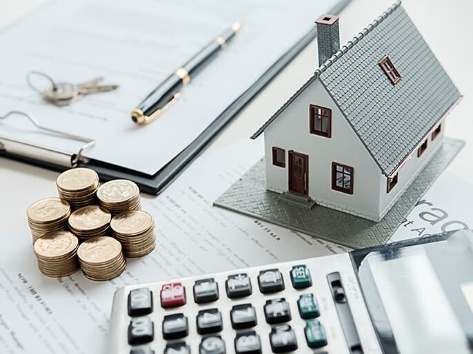 早急に現金化できることを表すイメージ写真(住宅模型・現金・電卓)